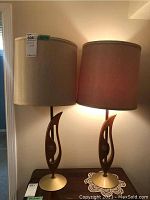 Pair of matching retro Mid-Century Modern table lamps side by side, lit to show design and lamp shade color.