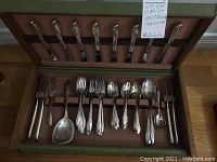 Full view of the flatware case open showing the utensils inside and minor wear on case interior and exterior.
