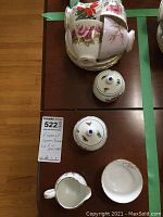 Top view of four teacups and saucers stacked, Royal Worcester salt shakers on table, Royal Adderley cream and sugar set.