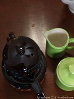 Dark Sadler teapot with chip on rim and crack on lid
