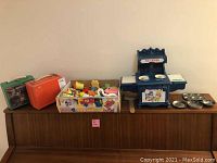 Wide view of all items: two vintage lunchboxes, box of baby toys, Holly Hobbie miniature hearth set with muffin tins on sideboard