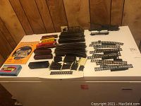 Full layout of track sections, train cars, and boxes on a table from overhead