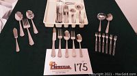 Full set of flatware including all types of utensils arranged on a table with a white plastic organizer tray.
