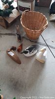 Wicker basket with ducks and wooden carvings arranged on floor