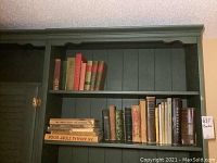 Shelf with two rows of vintage hardcover books including chemistry and literature subjects. Books vary in size and wear level.