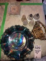 Overview of three sets of salt and pepper shakers arranged behind carnival glass handled covered dish and pressed glass dish, plus ornate brass dish