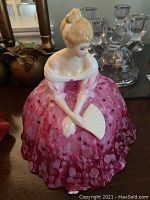 Front view of Royal Doulton porcelain figurine showcasing the floral pink dress and fan.
