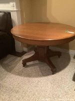 Full view of round tiger oak table on casters
