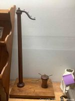 Complete view of the wooden thread winder showing tall vertical post with hooks and wooden base.