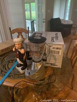 Photo showing Hamilton Beach toaster oven box, Black & Decker blender, and chef statue on table