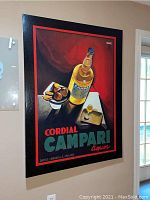 Full view of the Campari canvas wall art showing the bottle, glasses, and text on a red and black background.
