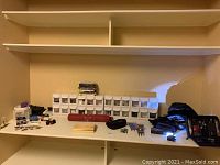 Overall display of dart items including cases, organizer, parts, and tools on shelf