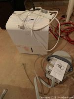 Overview of portable dehumidifier and ice therapy unit placed on floor