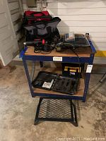 Photo showing entire lot arranged on a metal workshop table and metal step stool on ground.