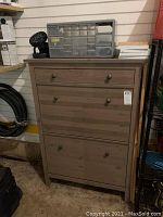 Wooden shoe storage rack with drawer, plastic container, and fan on top.