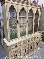 Front view of the oak stained cabinet base and hutch with glass-paneled doors and solid wood construction