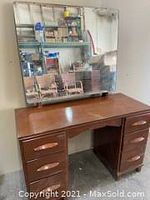 Front view of wooden makeup dresser with six drawers and wooden pulls topped with a large rectangular mirror, placement and condition visible.
