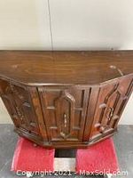 Front view of the cabinet displaying the geometric molded drawer fronts and overall shape.