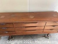 Front view of walnut dresser showing top surface and four drawer fronts with recessed handles.