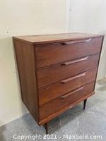 Front and side perspective of walnut tall boy dresser showing four drawers and tapered legs