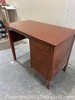 Front angle view of the wooden desk showing the two drawers and flat surface top.