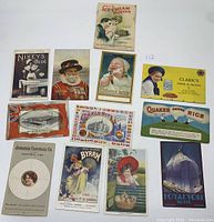 Photo of 11 vintage advertising postcards showing brands like Quaker Puffed Rice, Royal York Hotel, Clark's Pork & Beans, and a Jell-O Ice Cream Powder booklet.