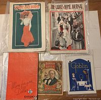 Five vintage magazines arranged on a flat surface, showing covers of Ladies Home Journal 1901 and 1902, Goblin 1921, Barnum Bailey magazine, and Eaton's 1937 catalog.