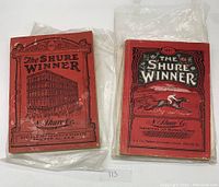 Photo of two red covered catalogs side by side, showing front covers with different illustrations and titles.