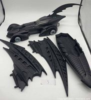 Main Batmobile body and four detachable wing parts laid out on white background.
