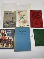 Photo showing all six books and pamphlets arranged on a white surface, including the titles ARK ROYAL, Cap Badges of the Canadian Expeditionary Forces, and others.