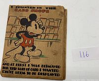 Front side of the vintage foldable card showing Mickey Mouse in front of a card shop with text