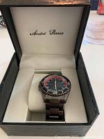 Open box displaying the Andre Picasso watch inside a branded cushioned case showing dial and band