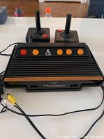 Atari Flashback 5 console showing front with AV cables and orange buttons.