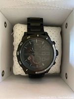 Black Diesel chronograph wristwatch resting on a white cushion inside the original box.