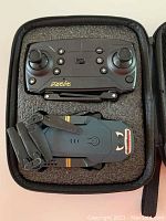 Collapsible drone and remote controller inside foam storage case.