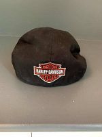Front view of black Harley Davidson cabbie hat with logo patch