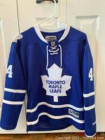 Front view of blue Toronto Maple Leafs jersey size medium with white accents, featuring number 44 and Toronto Maple Leafs logo.