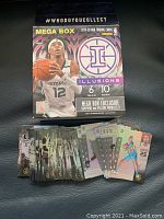 Photo showing a spread of 50 NBA basketball trading cards and the Panini Illusions Mega Box packaging