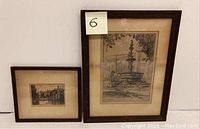 Two framed etchings side by side against a white wall, labelled lot number.