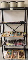 Full view of metal shelving containing fishing reels, lures, and fishing line spools arranged on four shelves.