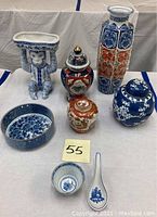 Group shot of eight porcelain pieces including vases, planter, jars and bowls