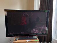 Photo of Samsung 50-inch flat screen TV with remote on table underneath.