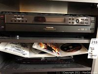 Toshiba 5-disc carousel changer with control buttons and display panel on front.