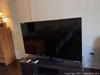 Front view of Samsung TV on wooden stand