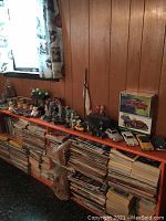 Wide view of shelf with assorted model cars, figurines, vases, snow globe, tabletop Christmas tree, ashtrays, and various collectibles.