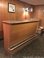 Front and side angle of mid century modern bar with marble top and wood finish.