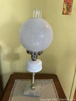Full view of vintage table lamp featuring white hobnail glass globe and smaller hobnail glass base on a square marble base with brass fittings.