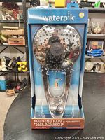 Front view of the sealed box containing the Waterpik Aquascape Ultra showerhead showing the product and branding.