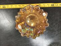 Top-down view of carnival glass bowl, showing the ruffled edges and starburst pattern at center.