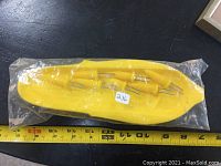 Top view of the kit showing the yellow plastic holder and four yellow-handled metal skewers in original sealed packaging, with measuring tape below for scale.